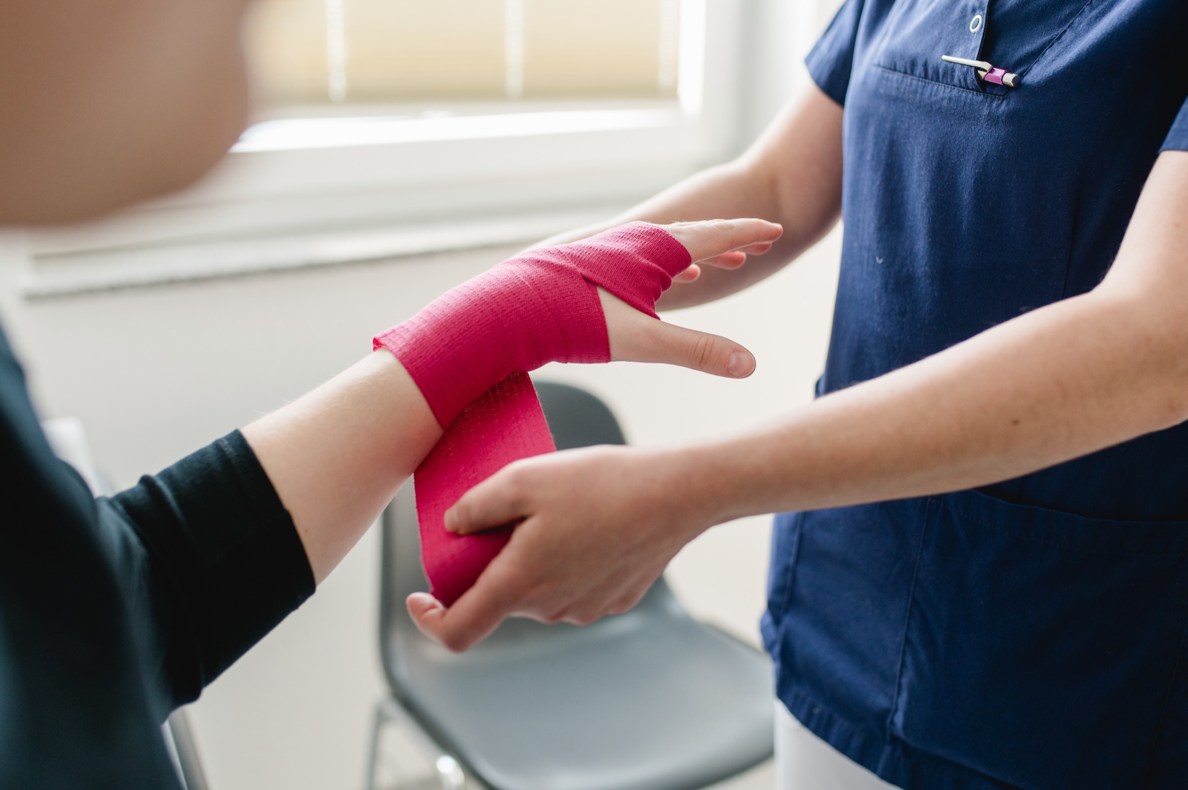 Eine medizinische Fachkraft hält die Hand einer Patientin